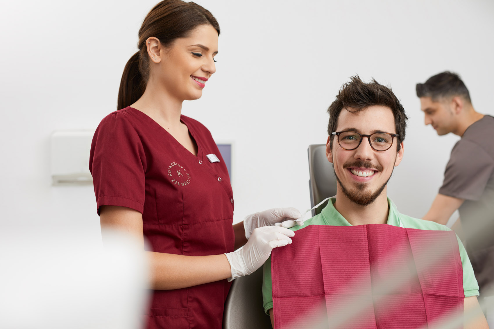 Ein Patient befindet sich im Behandlungszimmer, betreut von einer Mitarbeiterin von Ko'Konzept.